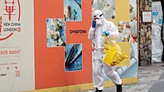 Житель Лондона идёт за покупками в костюме химзащиты
