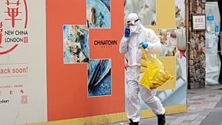 Житель Лондона идёт за покупками в костюме химзащиты