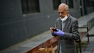 Un uomo con il viso parzialmente coperto da una mascherina, fuma una sigaretta a Pamplona (Spagna). 02/05/20