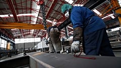 Operários de uma fábrica italiana trabalham de máscara devido à Covid-19