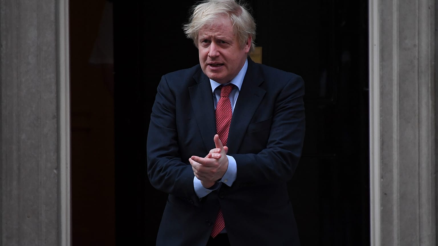 Britain's Prime Minister Boris Johnson joins in the applause on the doorstep of 10 Downing Street in London during the weekly "Clap for our Carers" Thursday, May 7, 2020. 