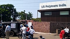 Policemen stand guard as people gather in front of an LG Polymers plant following a gas leak incident in Visakhapatnam on May 7, 2020