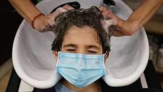 Une coiffeuse espagnole lave les cheveux d'une cliente dans son salon de Burgos le 4 mai 2020, pour la première fois depuis le début d'un confinement contre le Covid-19
