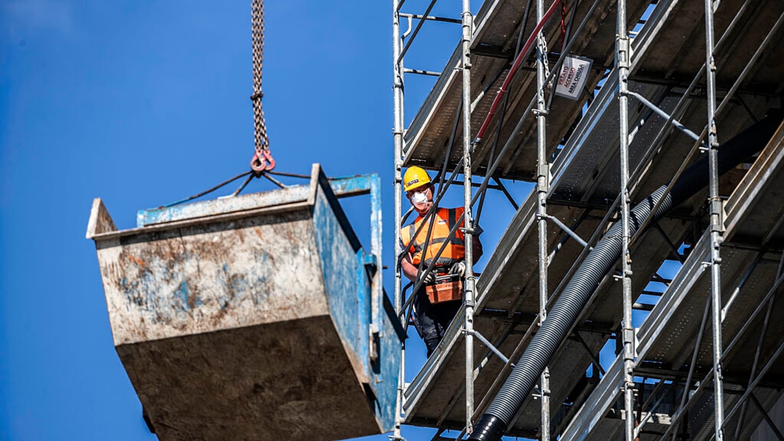 A worker operates at a construction site in Milan, Italy, Thursday, May 7, 2020.