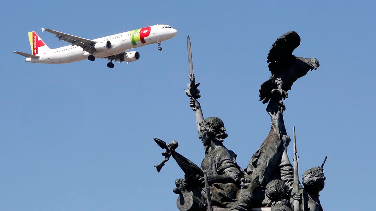 Um avião da TAP prepara-se para aterrar em Lisboa sobrevoando o monumento à Guerra Peninsular