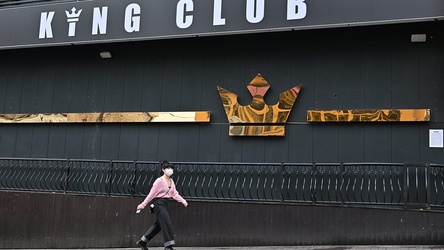 A woman wearing a face mask walks past a night club,on May 10, 2020. - South Korea