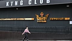 A woman wearing a face mask walks past a night club,on May 10, 2020. - South Korea