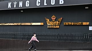 A woman wearing a face mask walks past a night club,on May 10, 2020. - South Korea