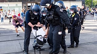 Police detain a protestor, during a demonstration on Alexanderplatz, in Berlin, Germany, Saturday, May 9, 2020.