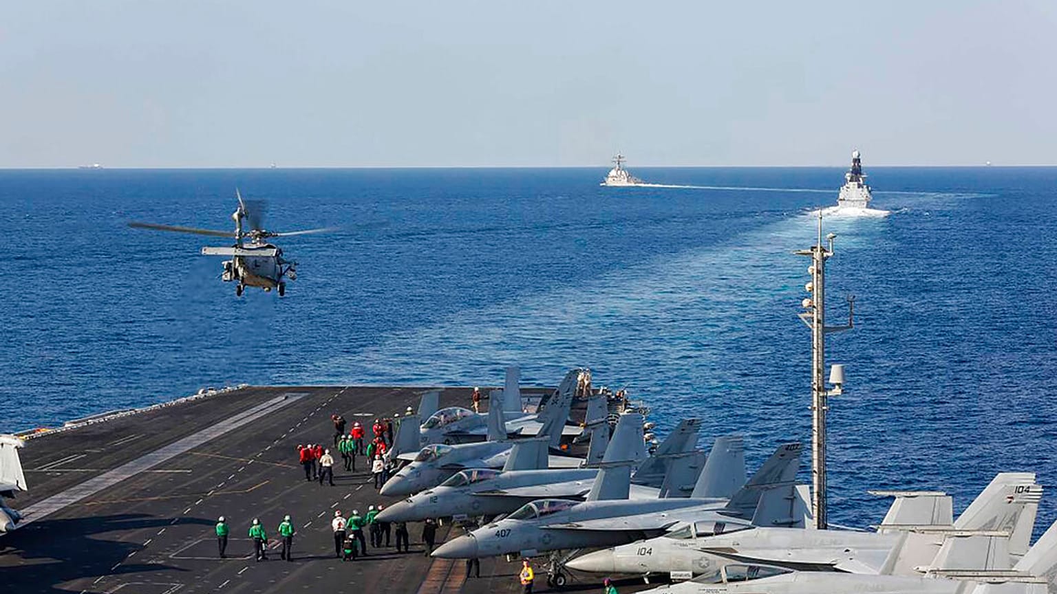 In this Tuesday, Nov. 19, 2019, photo made available by U.S. Navy, a helicopter lifts off of the aircraft carrier USS Abraham Lincoln as it transits the Strait of Hormuz.