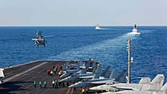 In this Tuesday, Nov. 19, 2019, photo made available by U.S. Navy, a helicopter lifts off of the aircraft carrier USS Abraham Lincoln as it transits the Strait of Hormuz.