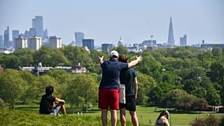 People enjoy the warm weather at Primrose Hill, as Britain faces its seventh week of lockdown due to the coronavirus outbreak, in London, Saturday, May 9, 2020.