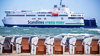 EIn Strand in Warnemünde bei Rostock: Im Hintergrund eine Fähre auf dem Weg nach Dänemark