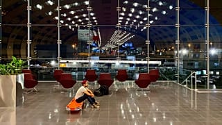 Mark Gonzales sur son lit de camp dans le terminal de l'aéroport Charles de Gaulle