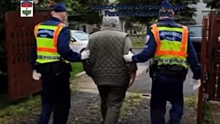 Uno dei due uomini accusati di procurato allarme portato via dalla polizia