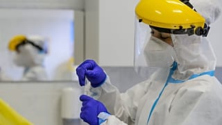 A koronavírusteszthez vett mintát kezel a Semmelweis Egyetem munkatársa a salgótarjáni Szerpentin úti orvosi rendelőben 2020. május 13-án