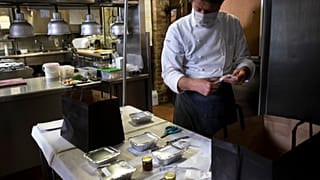 French chef Marc Lanteri wears a facemask as he prepares food packs in his restaurant in the Castle of Grinzane in Grinzane Cavour