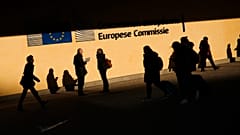 People walk past the European Commission headquarters in Brussels, Friday, Feb. 7, 2020