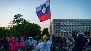 A man holds a Slovenian flag