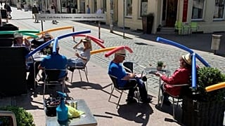 1,50 m Abstand sind weiter als man denkt: In diesem Café wird das mit ungewöhnlichem Kopfschmuck sichtbar gemacht.