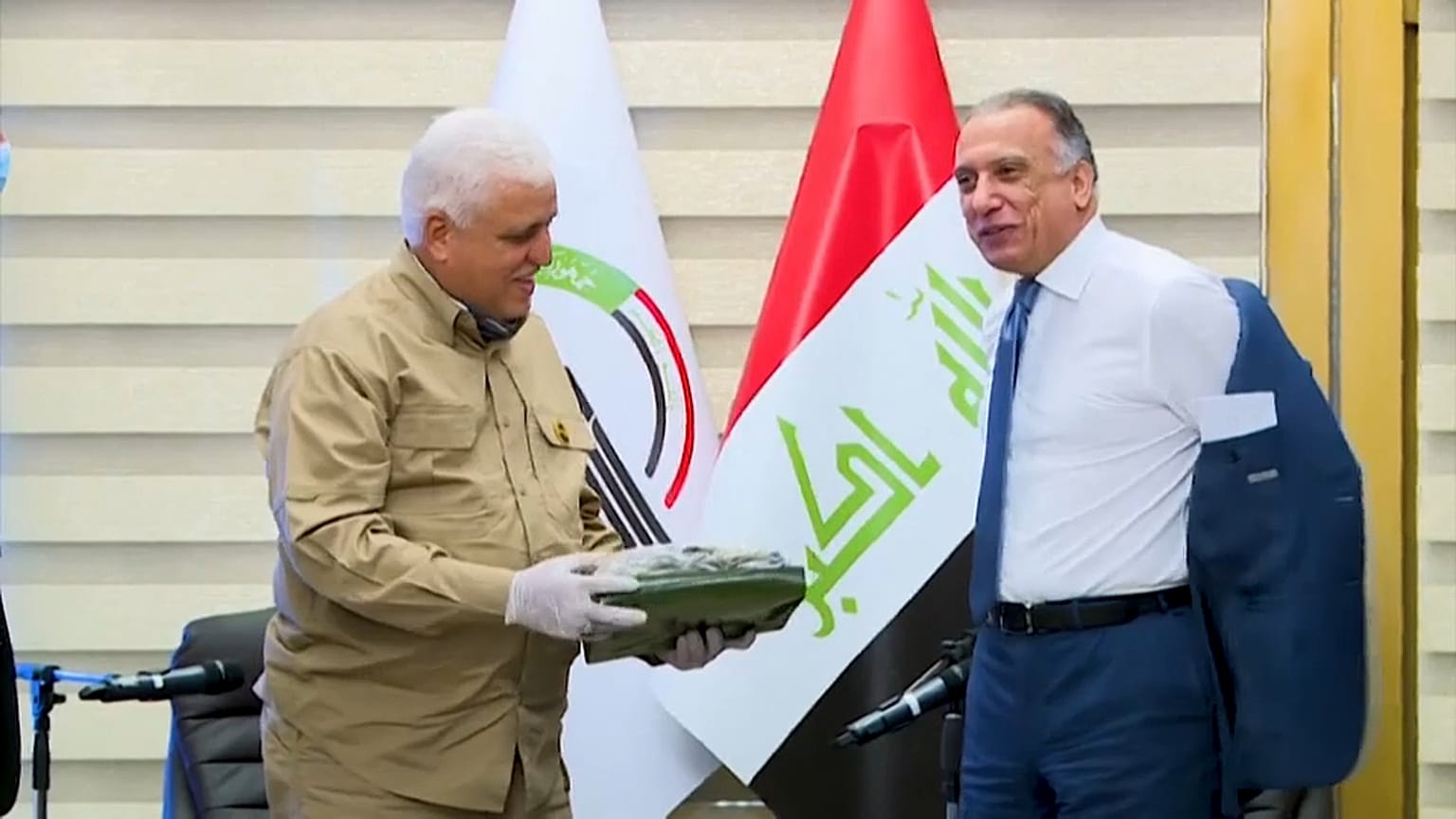 رئيس وزراء العراق الجديد مصطفى الكاظمي يتجهز للبس الزي العسكري الرسمي لقوات الحشد الشعبي أثناء اجتماع مع قائد الحشد في بغداد. التاريخ 17.05.20