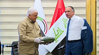 رئيس وزراء العراق الجديد مصطفى الكاظمي يتجهز للبس الزي العسكري الرسمي لقوات الحشد الشعبي أثناء اجتماع مع قائد الحشد في بغداد. التاريخ 17.05.20