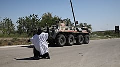 سيدة سورية ترمي مركبة روسية عسكرية مدرعة بمدينة أريحا بمحافظة إدلب السورية. 12/05/2020