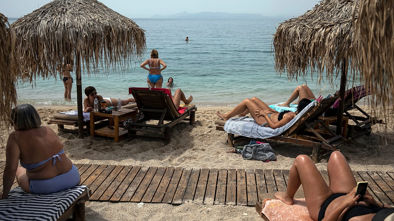 Swimmers enjoy the sea and the sun at Alimos beach, near Athens