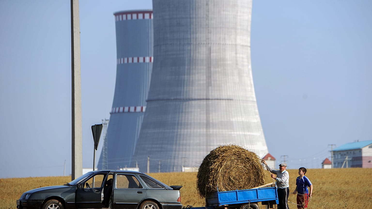 A pictureshows people transporting a bundle of straw close to the construction site of the first Belarus' nuclear power plant outside the town of Ostrovets