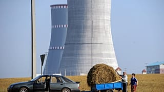 A pictureshows people transporting a bundle of straw close to the construction site of the first Belarus' nuclear power plant outside the town of Ostrovets