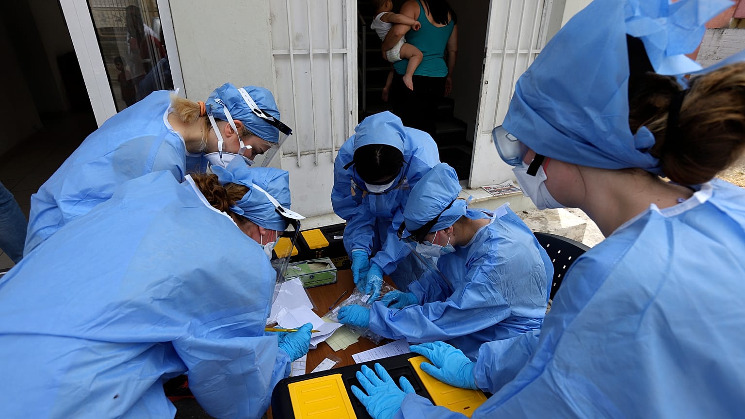 Medical workers wearing special suits to protect against coronavirus, conduct testing for COVID-19 