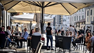 Personas sentadas en un café en Milán, Italia, el lunes 18 de mayo de 2020. 