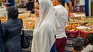 شابة سورية تسير وسط السوق المركزي في القامشلي بمحافظة الحسكة. 19/05/2020
