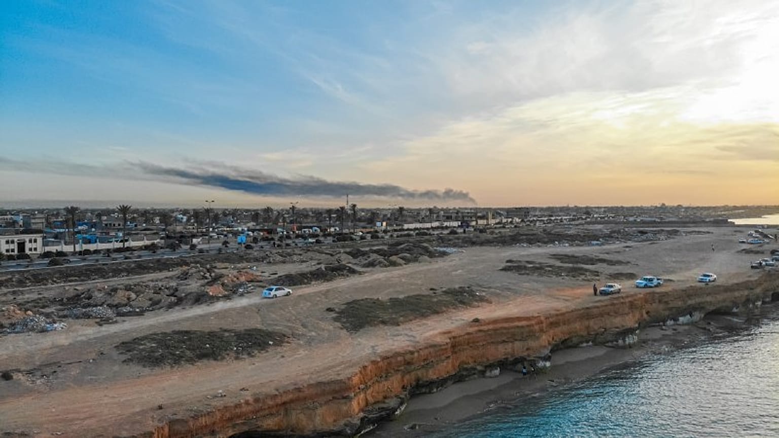 Smoke rises in Tripoli after a military base in the Abusleim area is hit.