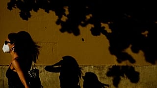 Una mujer camina con mascarilla por una calle de Pamplona