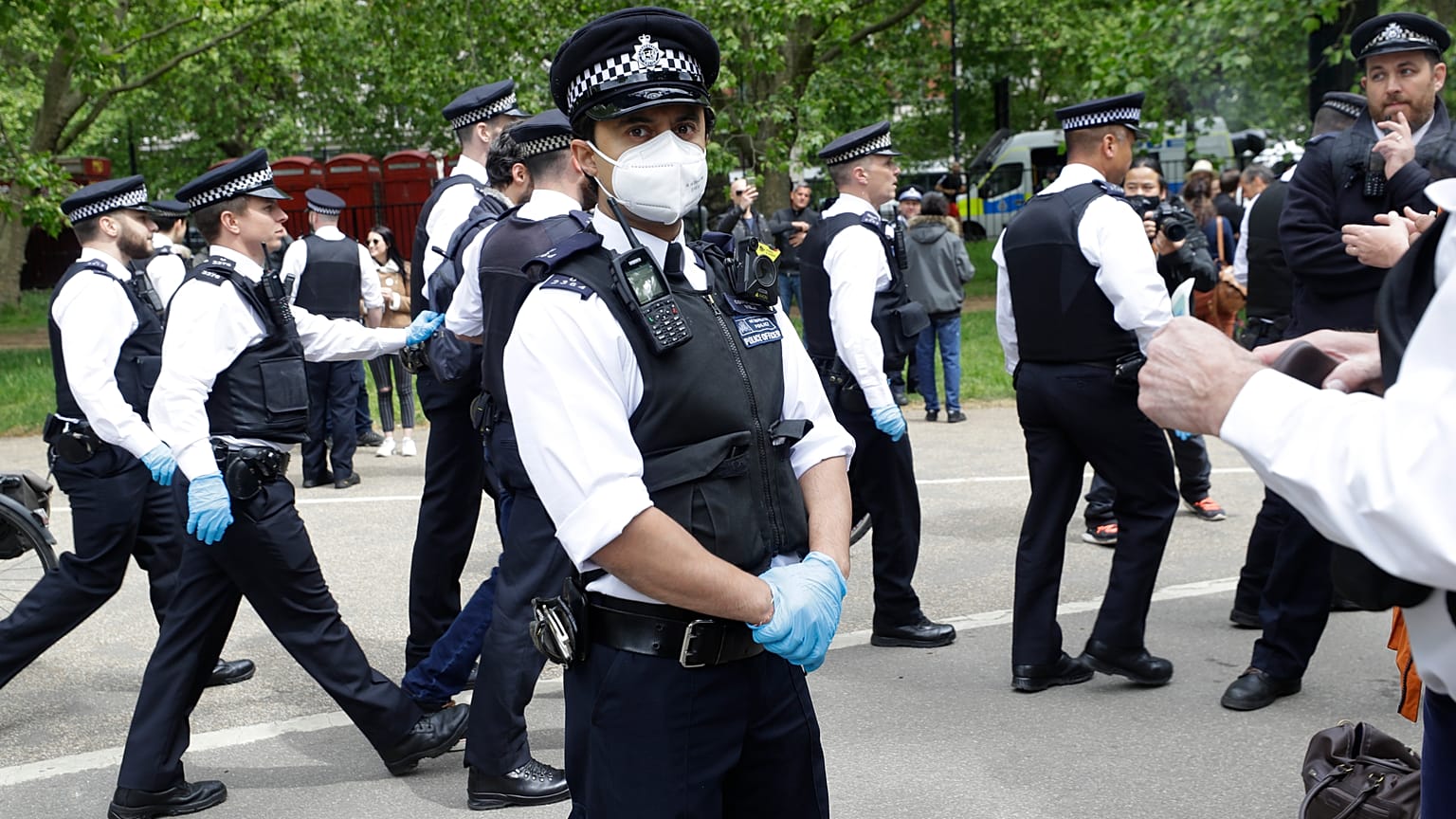 A police officer wears a face mask during a mass gathering protest organised by the group called 'UK Freedom Movement', in Hyde Park in London