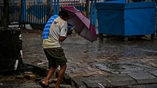 A man struggles to hold his umbrella and walk against high wind in Kolkata, India, Wednesday, May 20, 2020.