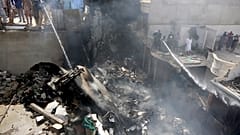 Des pompiers finissent d'éteindre l'incendie provoqué par la chute d'un avion sur Karachi - Pakistan - le 22 mai 2020