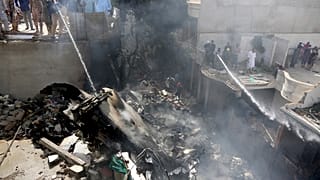 Des pompiers finissent d'éteindre l'incendie provoqué par la chute d'un avion sur Karachi - Pakistan - le 22 mai 2020