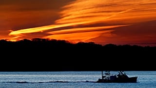 The lobster boat Deborah & Megan II motors out to sea at dawn, Thursday, May 21, 2020, off South Portland, Maine