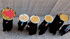 سيدات عراقيات يحملن على رؤوسهن بمدينة البصرة حلوى عيد الفطر الموافق ليوم غد الأحد 22/05/2020