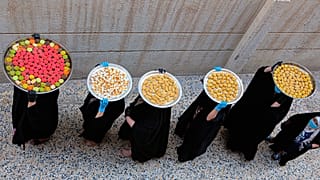 سيدات عراقيات يحملن على رؤوسهن بمدينة البصرة حلوى عيد الفطر الموافق ليوم غد الأحد 22/05/2020