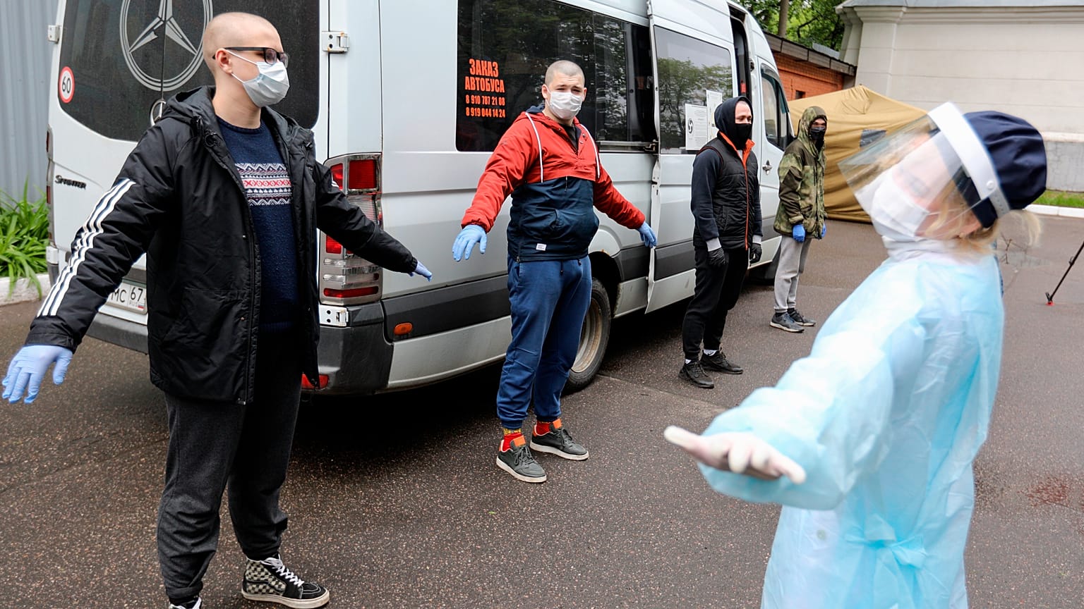 A group of conscripts, wearing face masks to protect against coronavirus, stand during a medical checkup at a military conscription office in Moscow,