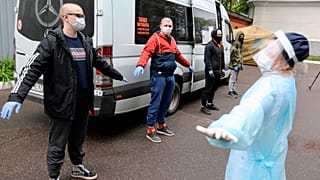 A group of conscripts, wearing face masks to protect against coronavirus, stand during a medical checkup at a military conscription office in Moscow,
