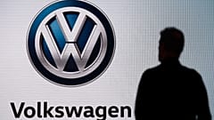 n this Wednesday, Nov. 28, 2018 file photo an attendee waits for the start of a news conference at the Volkswagen booth at the Los Angeles Auto Show.