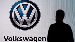 n this Wednesday, Nov. 28, 2018 file photo an attendee waits for the start of a news conference at the Volkswagen booth at the Los Angeles Auto Show.