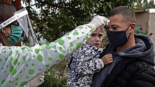 A health worker takes the temperature to a resident of Altos de San Lorenzo neighbourhood, near the city of La Plata, Argentina