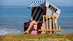 A woman is sunbathing on a beach chair by the sea in Norderney, Lower Saxony, Germany Tuesday May 26, 2020