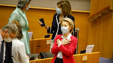 European Commission President Ursula von der Leyen, right, gestures hello to an MEP prior to addressing the European Parliament plenary in Brussels, Wednesday, May 27, 2020. 