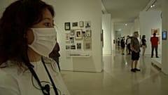Una joven con mascarilla observa una obra de arte en un museo de Málaga